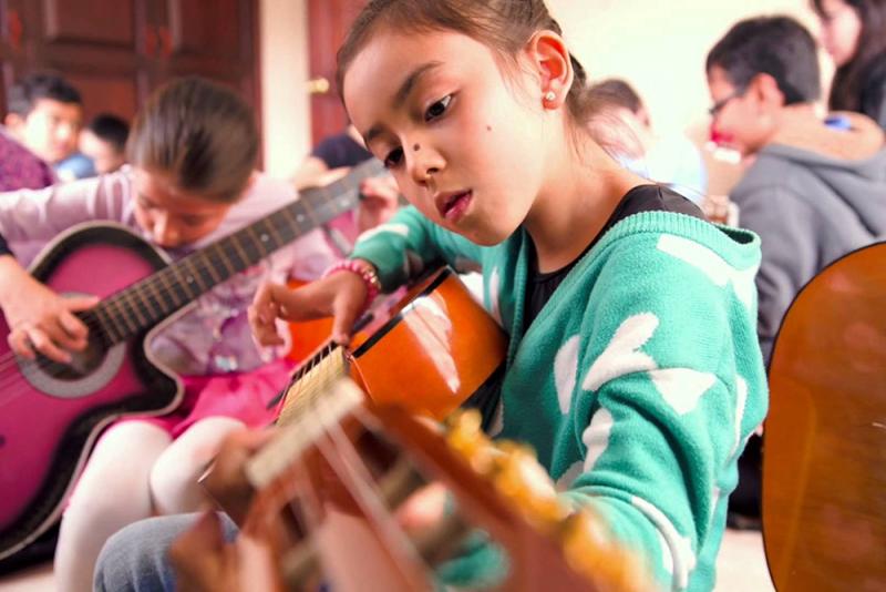 Niña tocando guitarra. Créditos de la foto: Internet