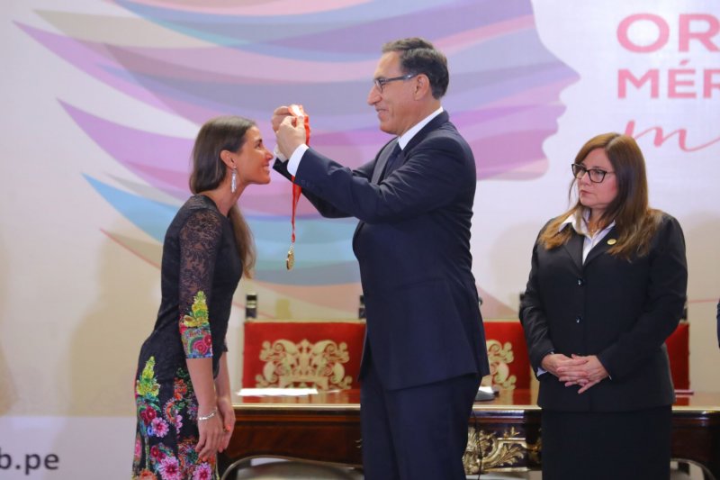 Evelyn recibiendo la medalla de la Órden 